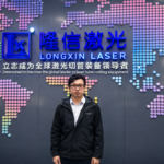 Eric Yueng at Longxin Laser headquarters in front of the company’s laser tube cutting and AI SmartCut branding
