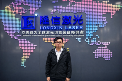 Eric Yueng at Longxin Laser headquarters in front of the company’s laser tube cutting and AI SmartCut branding