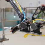 autonomous welding robot working underwater with bright metallic lighting and a clean glossy industrial aesthetic