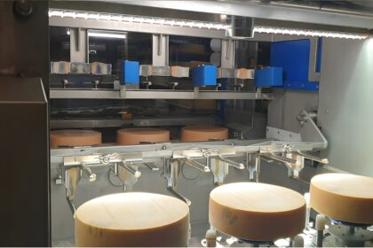 AI cheese production inspection system using machine vision camera and robotics monitoring cheese wheels during automated ripening process