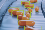 MVTec HALCON 26.05 AI object detection software identifying capsules on a high-speed pharmaceutical production line using machine vision technology