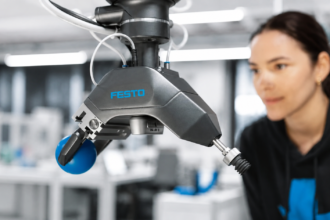 Festo GripperAI robotic gripper using AI vision to identify and handle mixed objects while an engineer monitors the system.