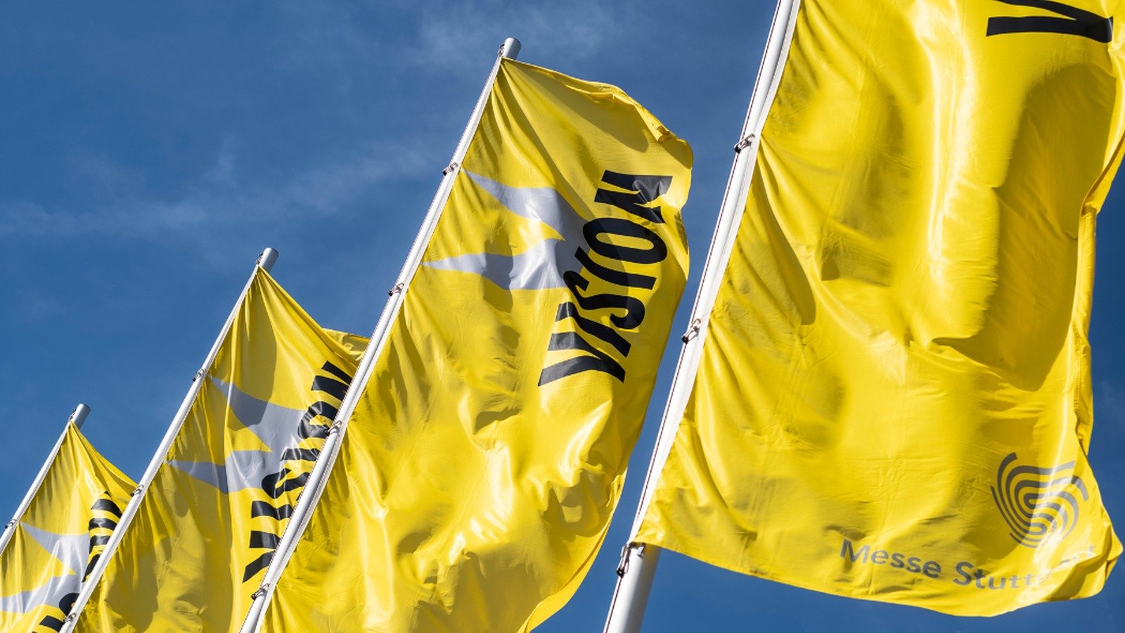 Yellow VISION flags flying outside Messe Stuttgart, host of the VISION 2026 machine vision exhibition.